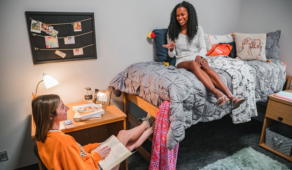 Two students having a conversation in a residence hall room.